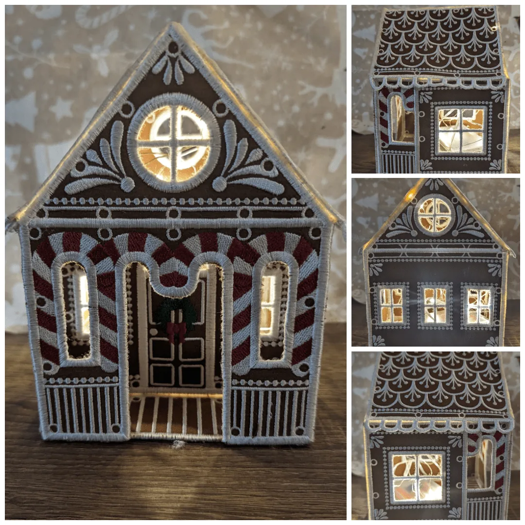 Gesticktes Lebkuchenhaus aus braunem Filz mit weißen und roten Verzierungen und beleuchteten Fenstern.