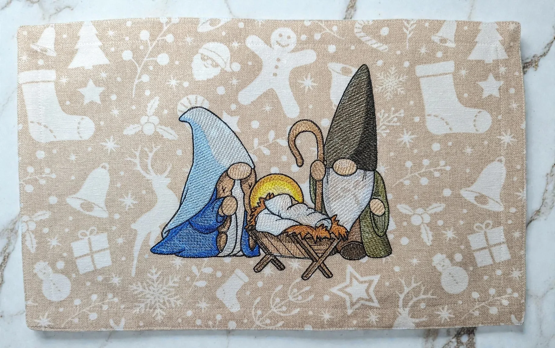 Platzdecke mit Gnome in einer Krippenszene, beige und blau, maschinengestickt auf Baumwolle