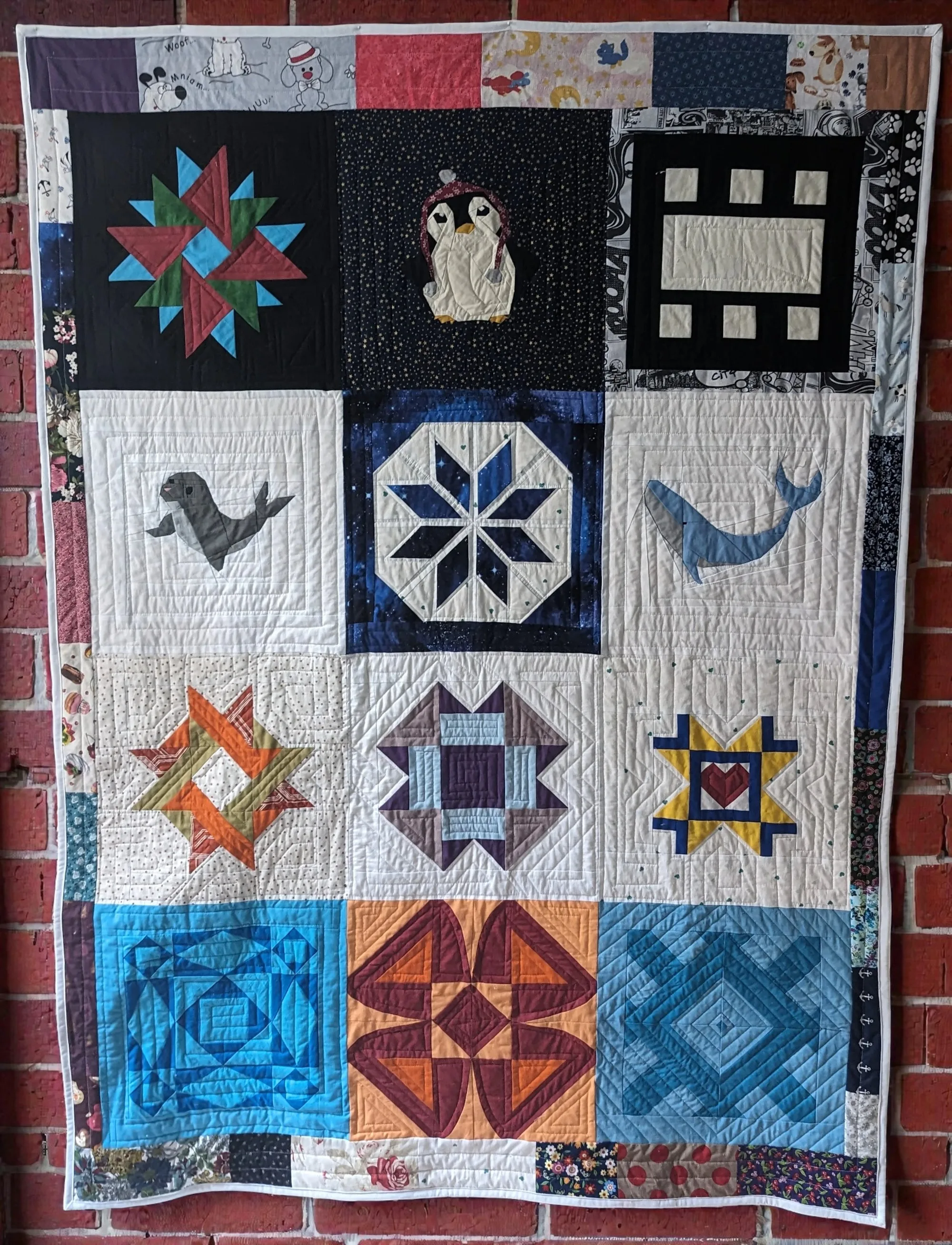 Quilt mit geometrischen und tierischen Motiven in verschiedenen Farben